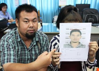 Warrant out for groping hooligan Reporter Klitichai Sapaklit points to a photo of Hathapong Hintua, wanted for sexual harassment of his girlfriend (holding photo).