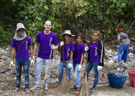 Volunteers from MAYs Urban Thai Dine Pattaya grab rakes and brooms to help clean up the litter.