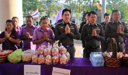 Pol. Col. Pramote Ngampradit (3rd right), superintendent of Nongprue Police Station, and Pol. Col. Thanayot Yungyuen (2nd right), senior investigation officer for Nongprue, present alms along with fellow officers and spouses.