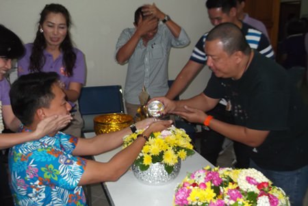 Officials and staff poor scented water into the palms of Superintendent Pol. Col. Prapansak Prasarnsuk.