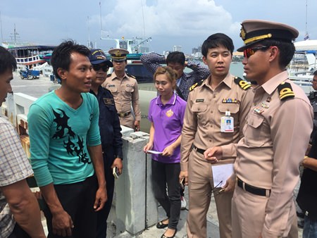 Ray (left) is interviewed by Navy officers after being pulled off a local fishing boat.