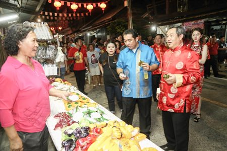 Former Culture Minister Sonthaya Kunplome (center) tastes some Chinese desserts at the opening of the fair.