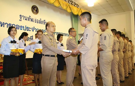 Rear Adm. Chatchawal Meesawad presents a certificate to one of 112 outgoing seamen at Sattahip Naval Base.