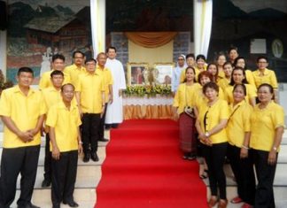 Members of the parish council stand in cordon in front of the pictures and relics of the two popes. In the background left is Rev. Peter Suraporn Suwichakorn.