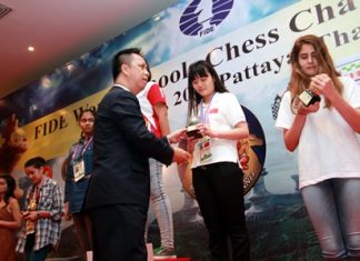 Neoh Kean Boon (centre), resident manager of Dusit Thani Pattaya, hands trophies to the winners of the Under-15 and 17 age categories for girls during the awards ceremony for the World Schools Individual Chess Championships 2015, Thursday, May 14.