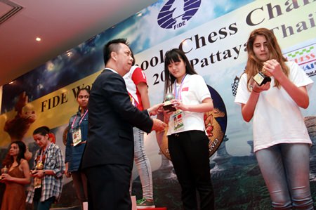 Neoh Kean Boon (centre), resident manager of Dusit Thani Pattaya, hands trophies to the winners of the Under-15 and 17 age categories for girls during the awards ceremony for the World Schools Individual Chess Championships 2015, Thursday, May 14.