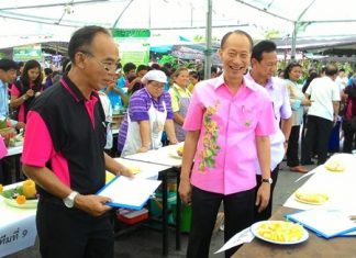 Gov. Khomsan Ekachai and friends try out the delicious pineapple on offer at the event.