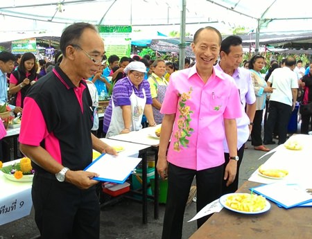 Gov. Khomsan Ekachai and friends try out the delicious pineapple on offer at the event.
