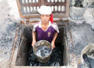 This is a prime example of the phrase, “It’s a dirty job but someone has to do it.” Dang holds up a bucket of sludge he and his fellow countrymen have been hired to dig out from the local drains.