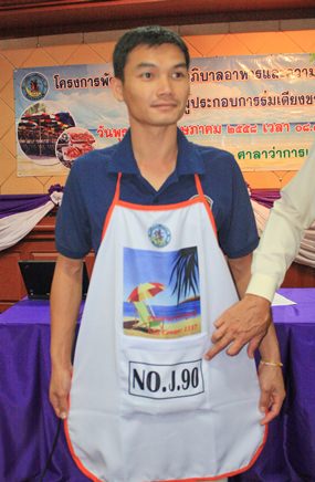 Officers hand out aprons to Jomtien Beach vendors, advising them they should wear them every day.
