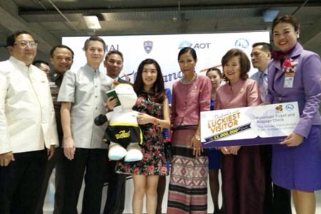 Vu Minh Phuong (center, holding stuffed doll) became the 13-millionth tourist visiting Thailand this year.