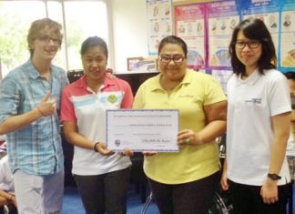 St. Andrews CAS students deliver a 100,000thb check to Operation Smile directors.