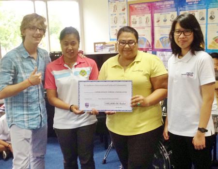 St. Andrews CAS students deliver a 100,000thb check to Operation Smile directors.