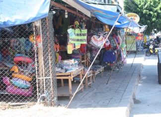 Vendors in Naklua are once again encroaching on public footpaths, causing pedestrians to veer out into the street to get past, as can be seen all the way down the street.