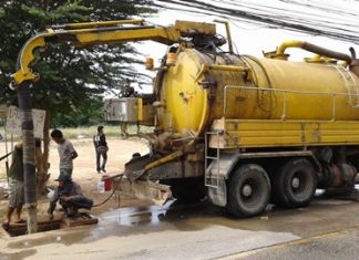 Workers from Mario Engineering Ltd., use vacuums and other equipment to suck rubbish, plastic bags, mud and other objects out of the drains along Soi Khao Talo.