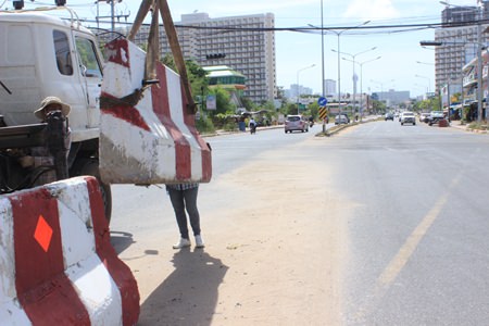 Workers from Chaiwat Kanthang Co., Ltd. lower concrete barriers at the Bunkanchanaram Intersection to block traffic going to & from Jomtien Beach Road and Sukhumvit Road.