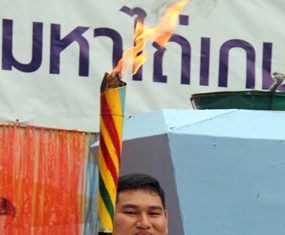 Former Paralympian weightlifter Prakit Thongsang carries in the flame to start the Mahathai Games 2015.