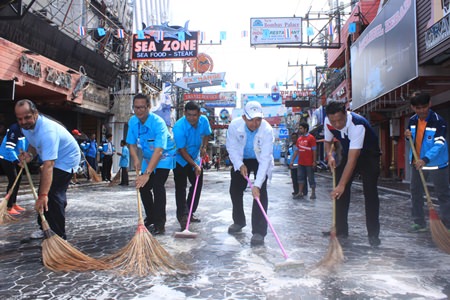 Mayor Itthiphol Kunplome (center, in white) helps scrub Walking Street with city council members, representatives from the city’s 42 communities and business owners on Walking Street.
