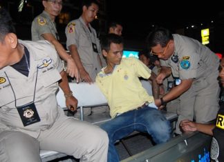 Klitsana Srisaiyud is wrestled into the police pickup to be escorted to the station for interrogation.