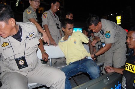Klitsana Srisaiyud is wrestled into the police pickup to be escorted to the station for interrogation.