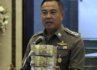 In this image taken from video, National Police Chief Somyot Poompanmoung holds a cash reward at a press conference in Bangkok, Monday, Aug. 31, 2015. (AP Photo/AP Video)