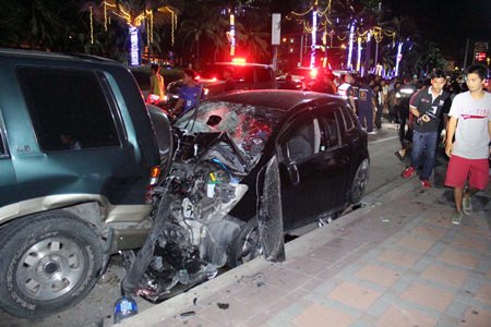 A woman lies dead in the street (background) after being struck by a car (foreground) driven by an unlicensed 17-year-old boy.