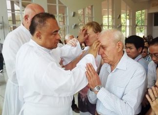 Fr. Corsie Legaspi lays his hands on the forehead of those who seek help.