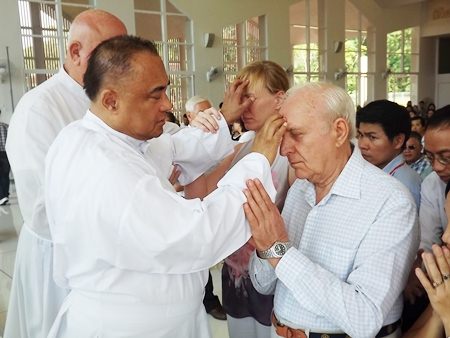 Fr. Corsie Legaspi lays his hands on the forehead of those who seek help.