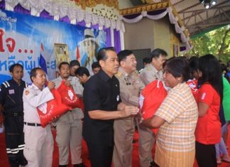 (L to R) Project Director Manus Nonuch, Chonburi Deputy Governor Phawat Lertmukda, and Banglamung District Chief Chakorn Kanjawattana help distribute 500 royal emergency bags to flood victims from HRH Princess Ubolratana.