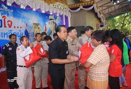 (L to R) Project Director Manus Nonuch, Chonburi Deputy Governor Phawat Lertmukda, and Banglamung District Chief Chakorn Kanjawattana help distribute 500 royal emergency bags to flood victims from HRH Princess Ubolratana.