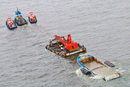 Tugboats begin towing the sunken vessel to a dockyard in Muang District of Samut Prakan.