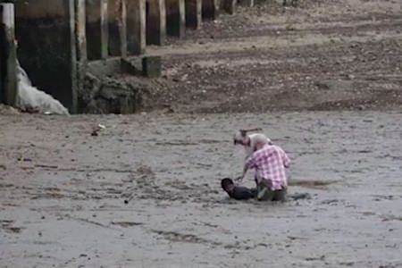 In this image made from video provided by Theerasak Saksritawee, Thai construction worker Chat Ubonchinda lies in the mud as he helps two unidentified Norwegian bird watchers who were sinking into a mudflat in Krabi, southern Thailand, Friday, Oct. 16. Chat lay down in the mud to allow the pair to use his body to pry themselves to safety. (Theerasak Saksritawee via AP)