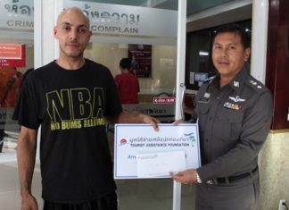 Briton Aser Ubus receives 6,000 baht from Kwanchanok Thana, representing the Tourist Assistance Foundation.