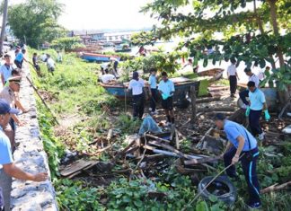 Sailors and officers join community residents in cleaning up the shoreline to commemorate Navy Day in Thailand.