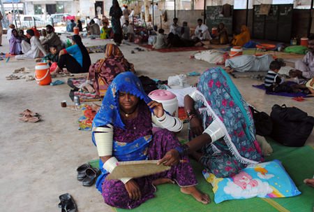 In this June 25, 2015 file photo, people sit outside a local hospital where hundreds of people are admitted suffering from heatstroke and dehydration due to sever weather in Hyderabad, Pakistan. Earth’s wild weather this year is bursting the annual heat record, the World Meteorological Organization announced Wednesday, Nov. 25. (AP Photo/Pevaiz Masih, File)