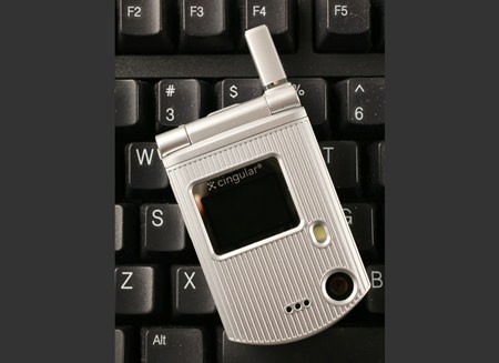 A C3 flip phone from Pantech is shown, on a keyboard for size comparison, in New York. More than 90 percent of smartphone users trade up for newer models within two years, according to experts. But a fraction of the population continues to cling to older phones, some 3 to 4 years old, or more. (AP Photo/Mark Lennihan, File)