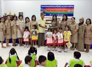 Members of the Rotary Club of Pattaya help stock the shelves of the Pattaya School No. 7 library with a donation of books.