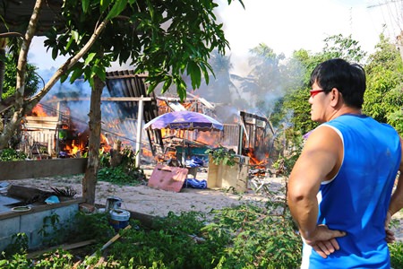 Noppong Srisai looks on as his house and all his belongings go up in smoke on Christmas Day.
