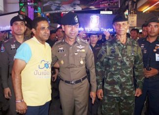 Law enforcement officials toured Walking Street in South Pattaya to assure tourists they were safe, with some officers even holding lighted signs to publicize their point.