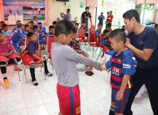 Khet Udomsak teaches local kids to swim An instructor shows students some of the techniques needed to save a drowning victim.