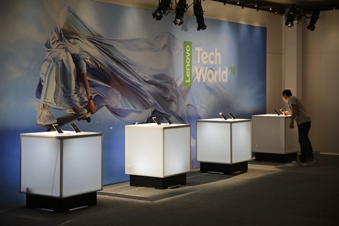 Sam Vang arranges a display of the new Phab2 Pro phone at the Lenovo Tech World event, Thursday, June 9, 2016, in San Francisco. (AP Photo/Eric Risberg)