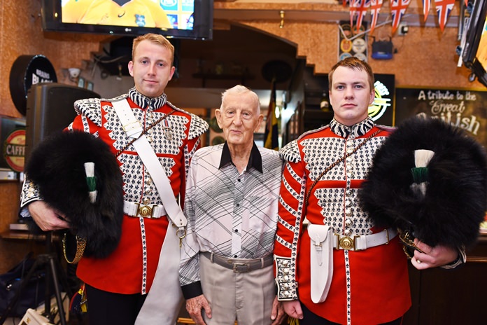 The oldest member of the Thailand branch of the Royal British Legion, 93 year old World War II veteran Archie Dunlop, is flanked by the Welsh guards.