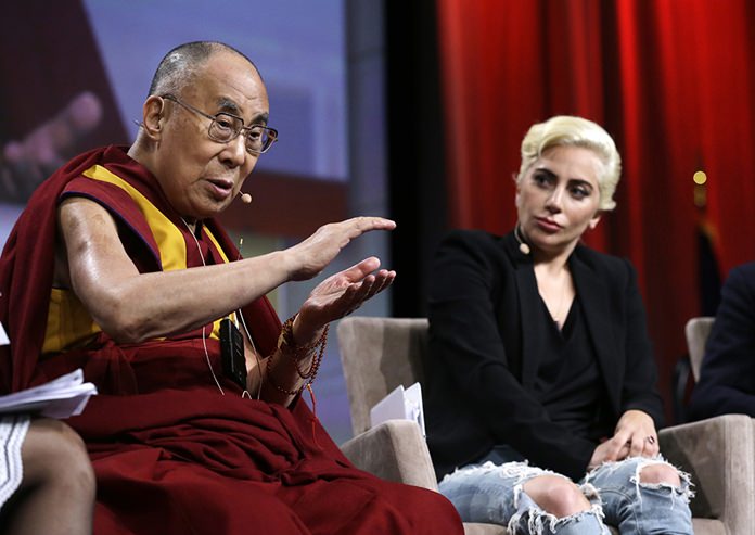Lady Gaga listens as the Dalai Lama speaks during a question and answer session at the U.S. Conference of Mayors in Indianapolis, Sunday, June 26, 2016. (AP Photo/Michael Conroy)