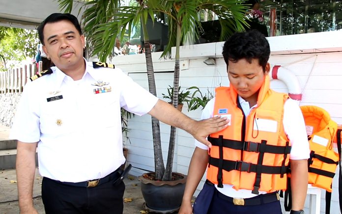 Regional Marine Department Director Eakarak Kantaro (left) displays a regulation life jacket that all tourist boat operators must have enough of on board for each passenger and crew.