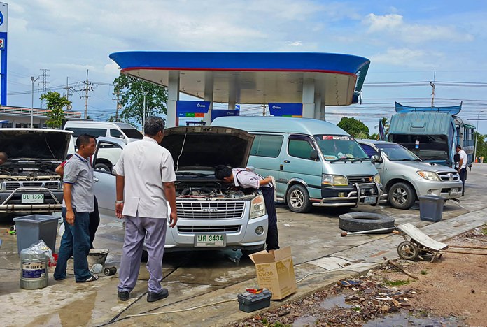 Mechanics work on stalled vehicles after they had filled up with petrol diluted by storm water that had seeped into the station’s holding tanks.