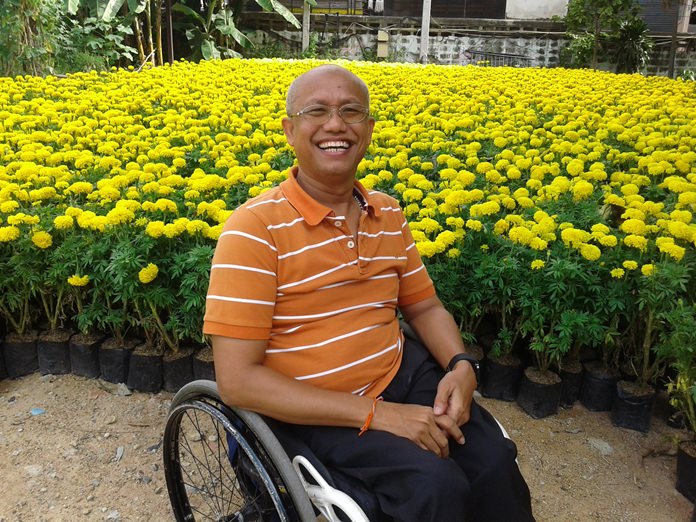 School executive Manop Eimsa-ard presides over the opening of a market selling flowers planted by disabled students for Mother’s Day.
