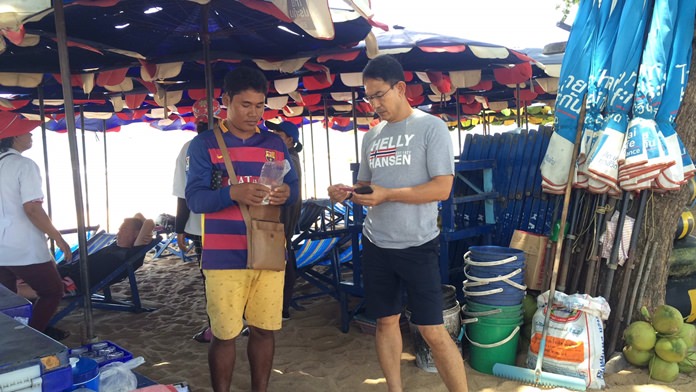 Cambodian vendor Sonauean Aoen (left) has been reprimanded for chasing away tourists who opted to bring their own towel and not rent a beach chair from him.