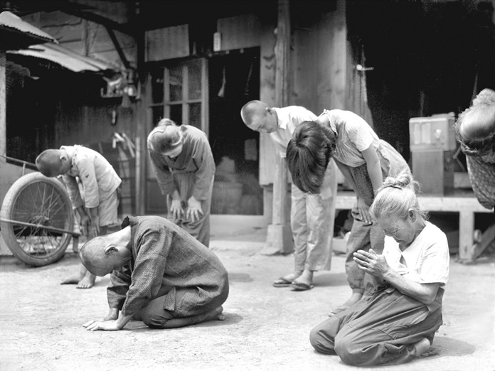 In this Aug. 15, 1945, file photo, Japanese people lower their head toward the Imperial Palace in Tokyo, as then Japan's Emperor Hirohito announces on radio that Japan was defeated in the World War II. (Kyodo New via AP, File)