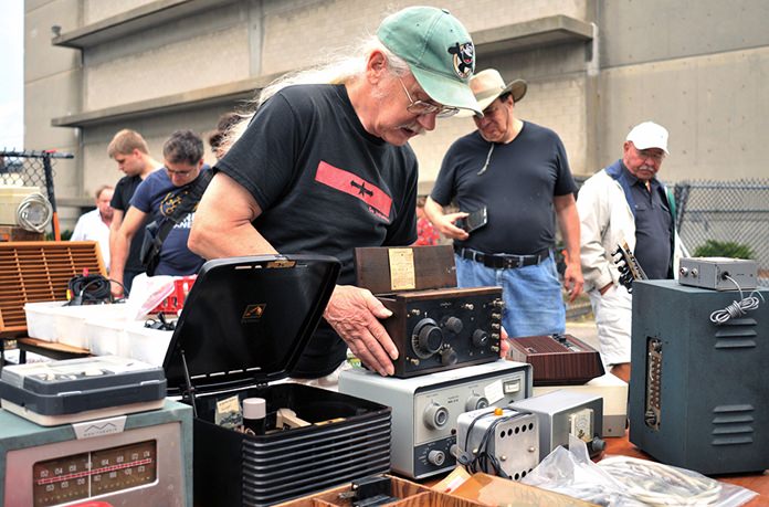 Vendor Chuck Ochs shows a 1921 Crosley Model 51 radio, priced at $100, at MIT’s Radio Society flea market. (AP Photo/Collin Binkley)