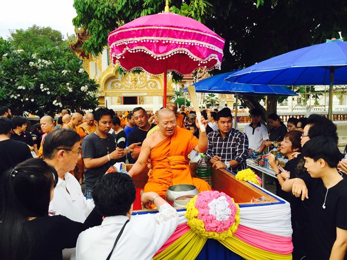 The abbot at Wat Chaimongkol blesses the congregation with holy water.